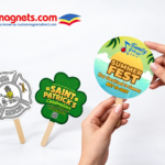 Custom paper hand fans on wooden sticks featuring fire rescue, St. Patrick's celebration, and summer fest designs from Custom Magnets Direct